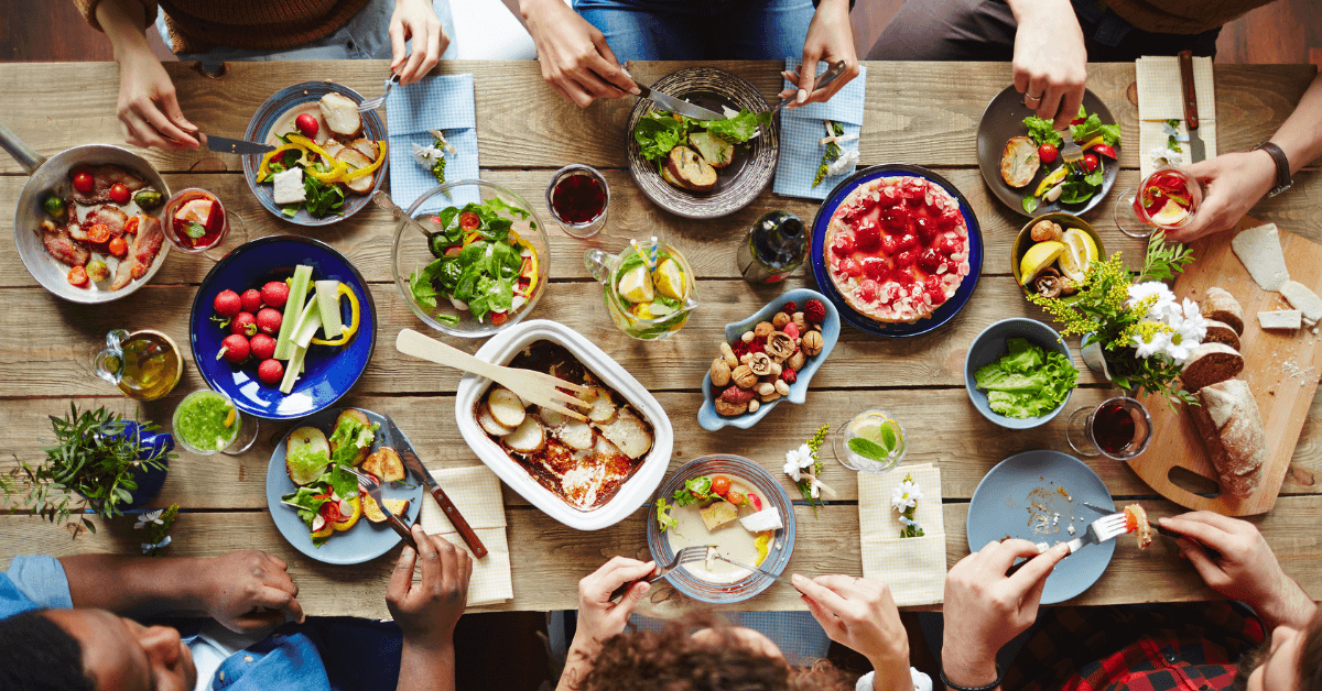 people eating at table with food drinks