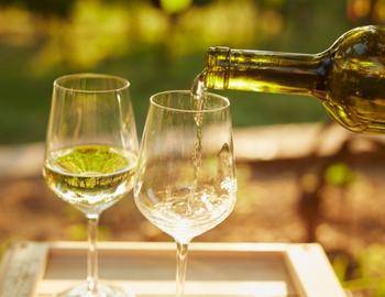 bottle of white wine poured into glasses