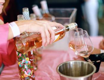 woman pouring pink wine into glass